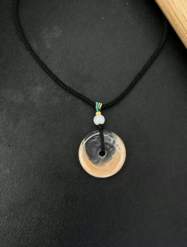 Clear round pendant with light pet fur on a black cord